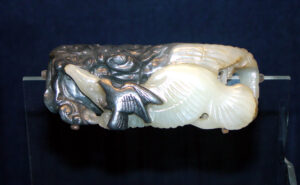 Jade carving: a pair of birds flies among the clouds; undercutting and contrast, between the birds and their background, lends definition and spatial depth to the scene.